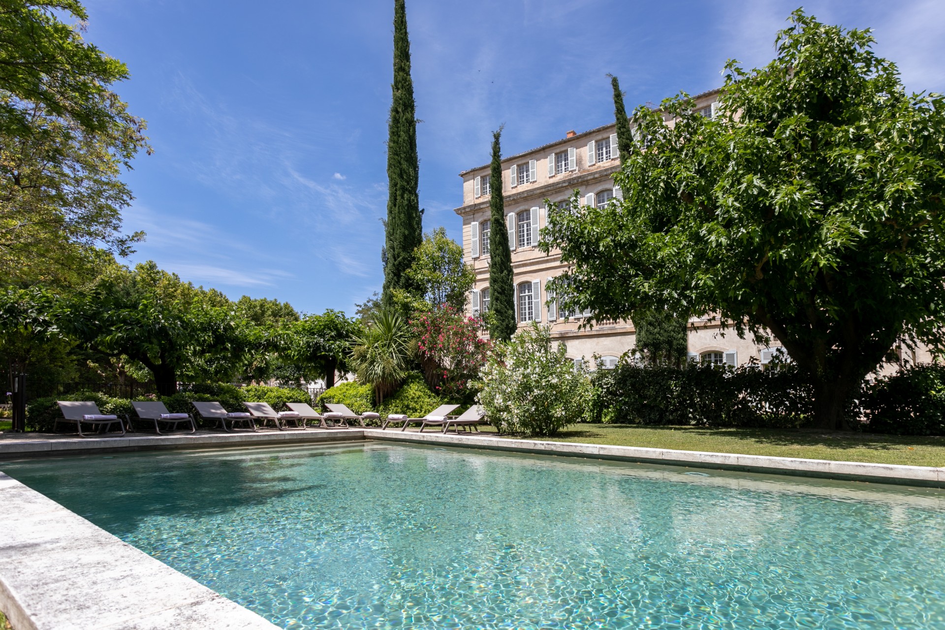 a pool with chairs in front of a building