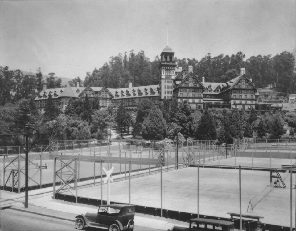 a large building with a tennis court and trees