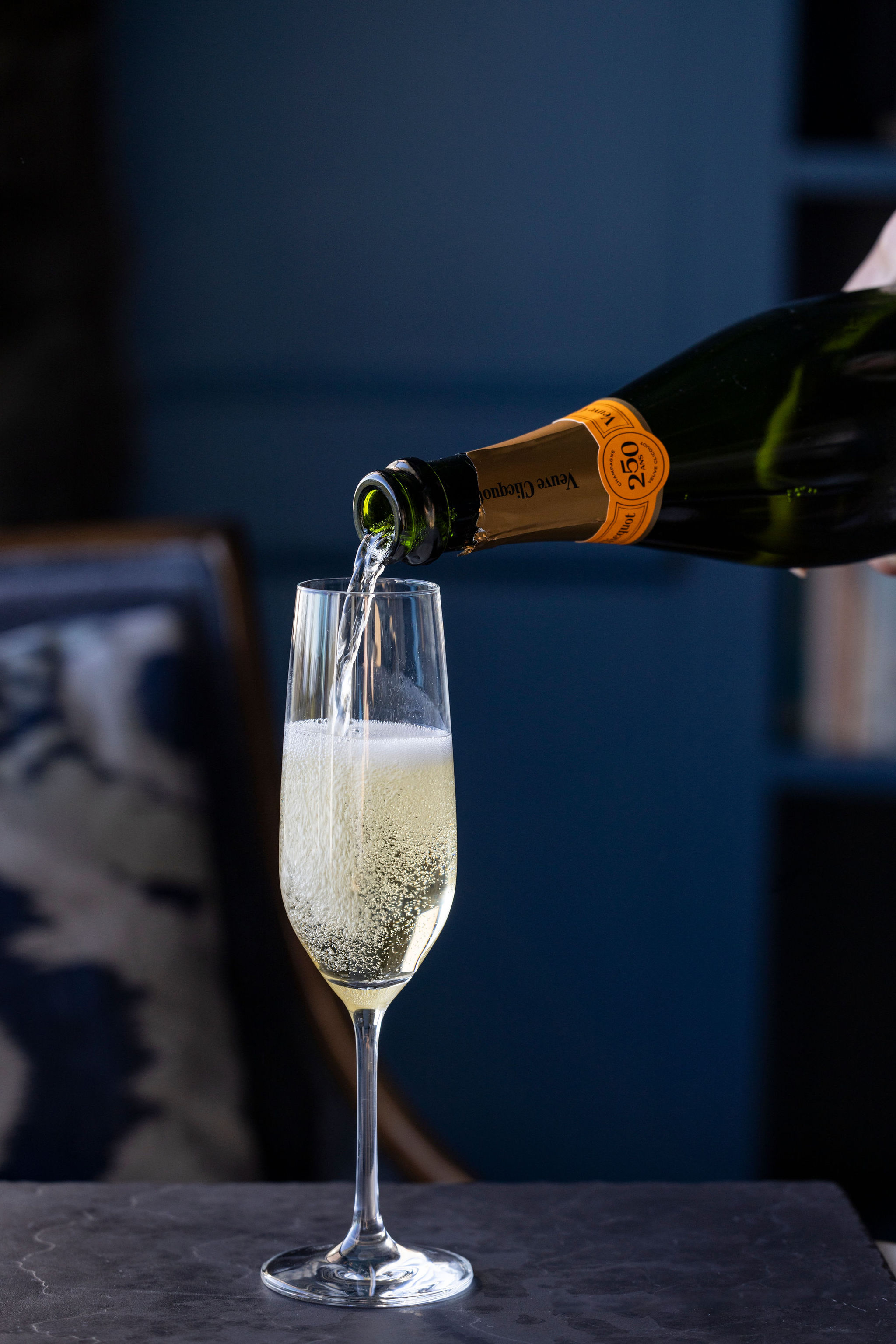 a person pouring a glass of champagne