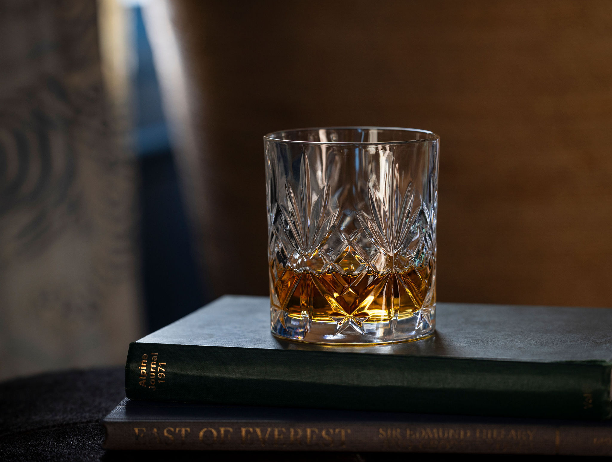 a glass of whiskey on a book