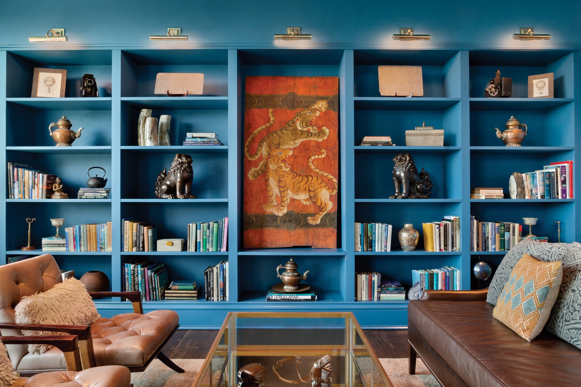 a blue bookshelf with a couch and a painting on it