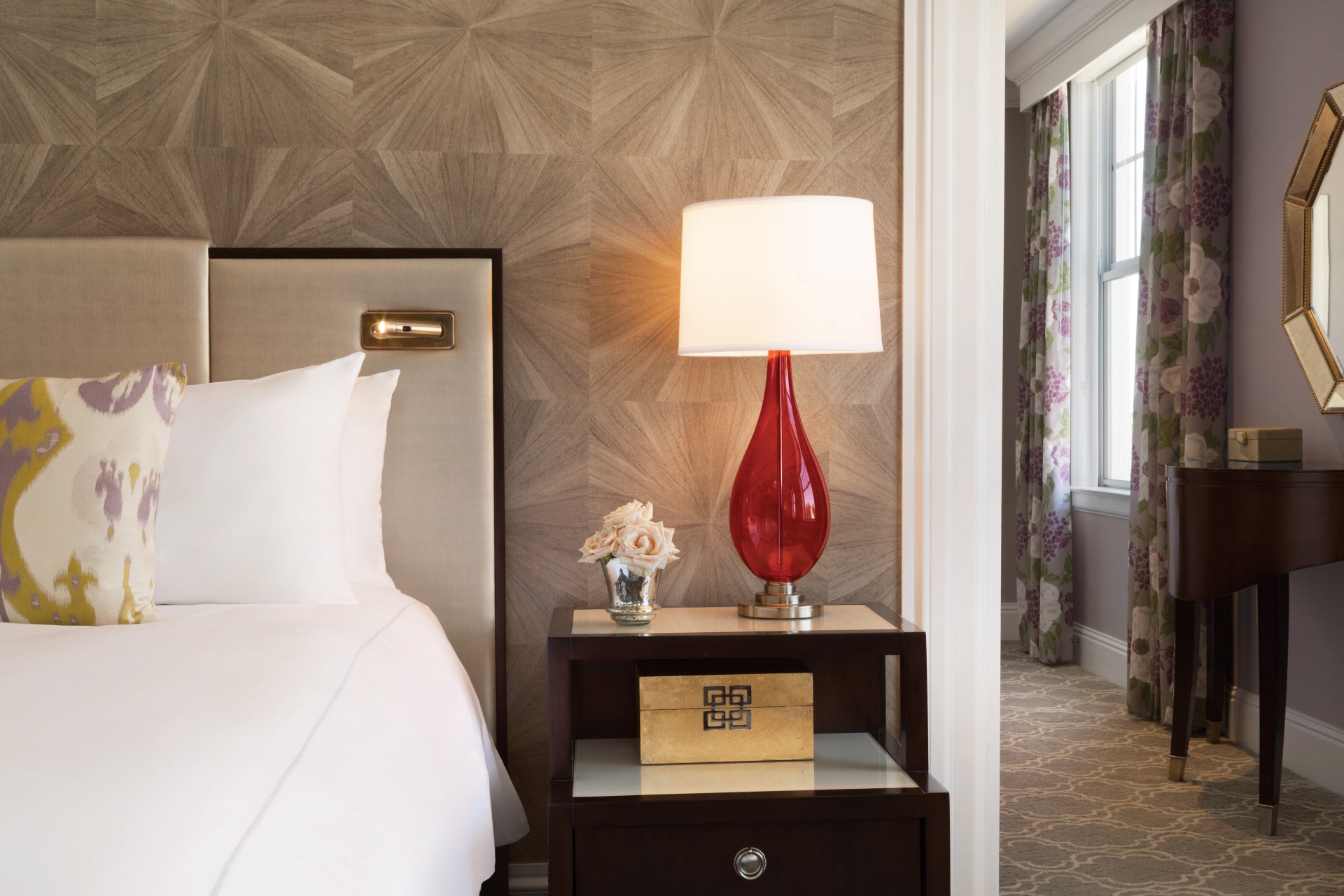 a lamp on a table next to a bed