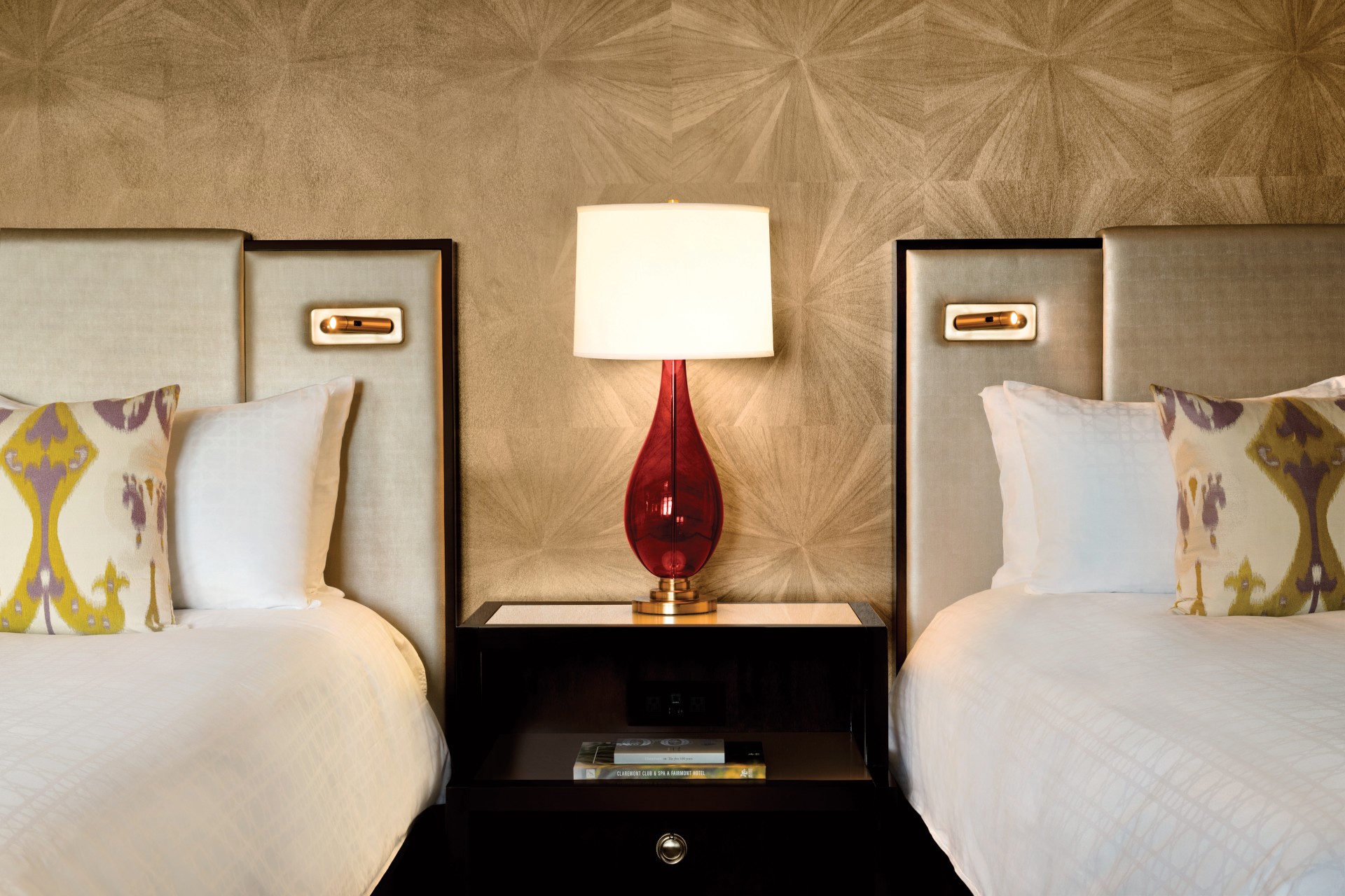 a lamp on a table next to a bed