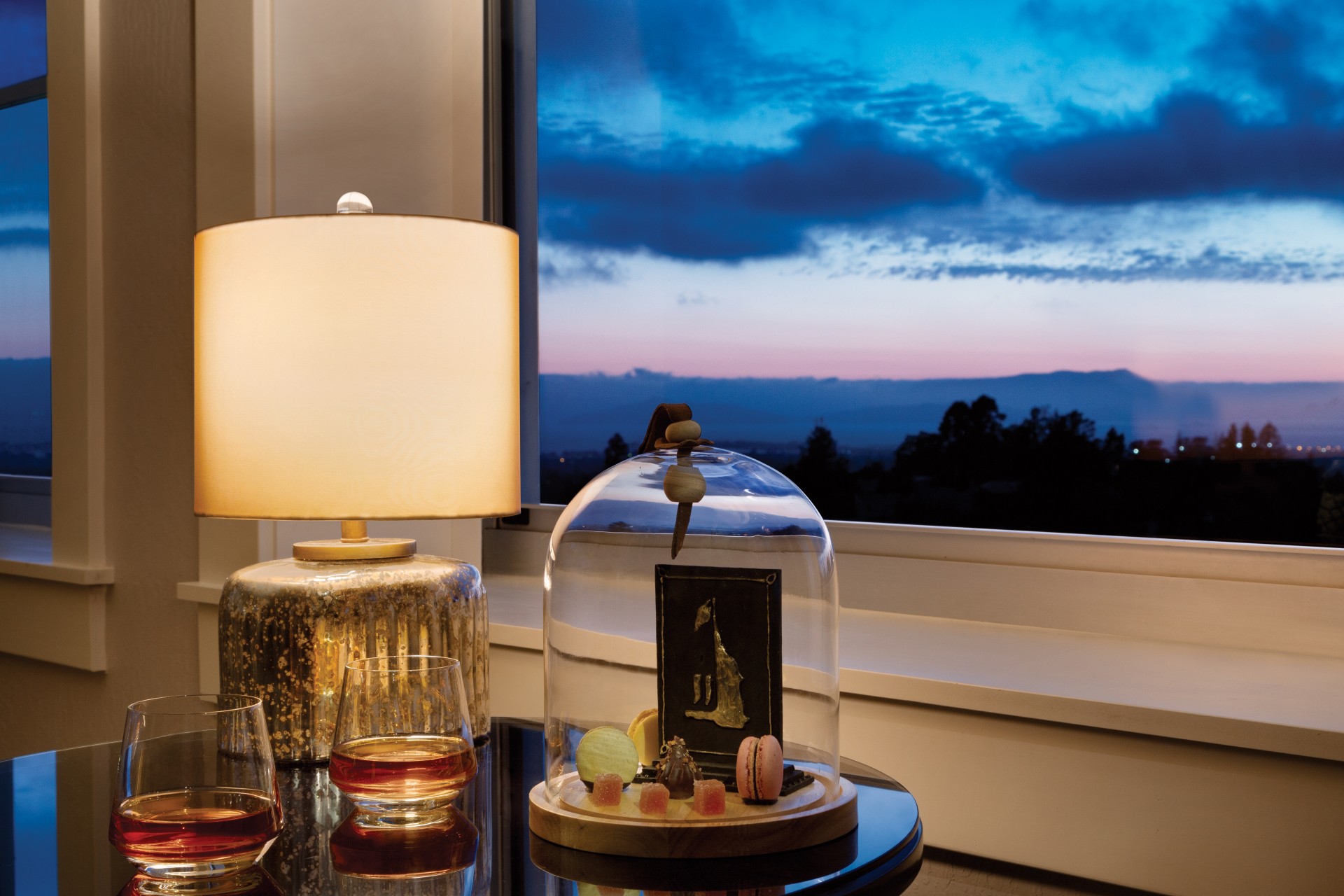 a table with a lamp and a glass dome