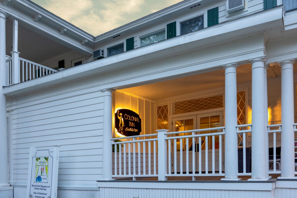 a white house with a sign on the front porch