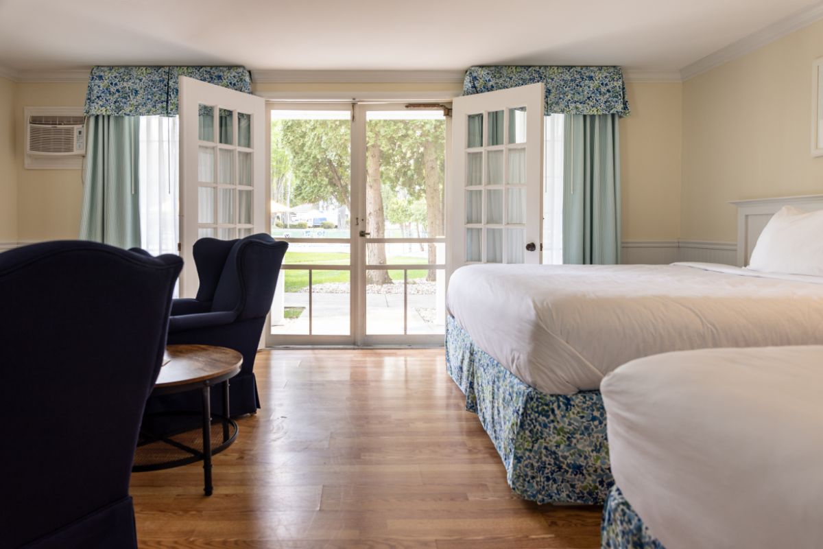 a room with two beds and chairs