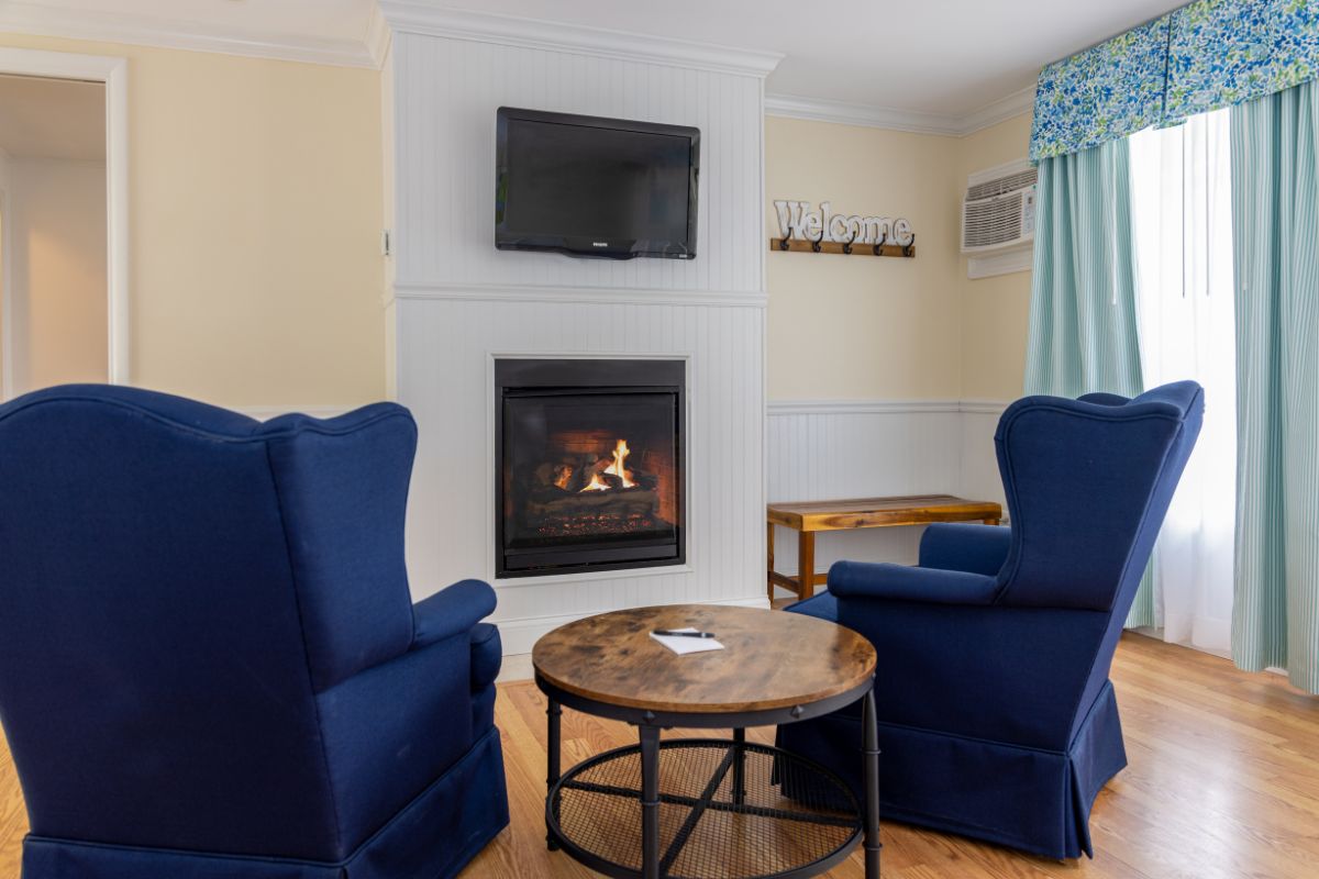 a room with a fireplace and blue chairs