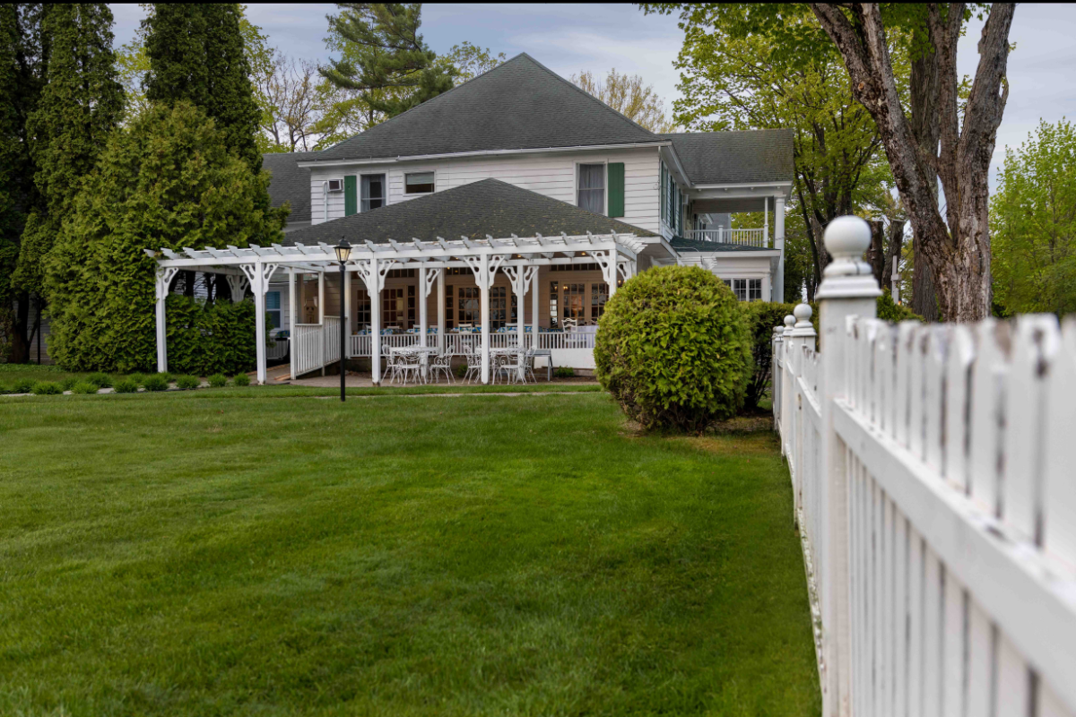 a white house with a white pergola and a white fence