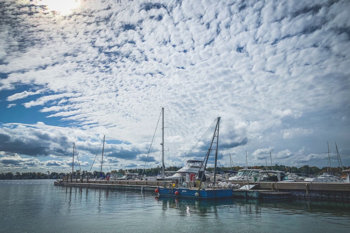 a dock with boats and a cloudy sky