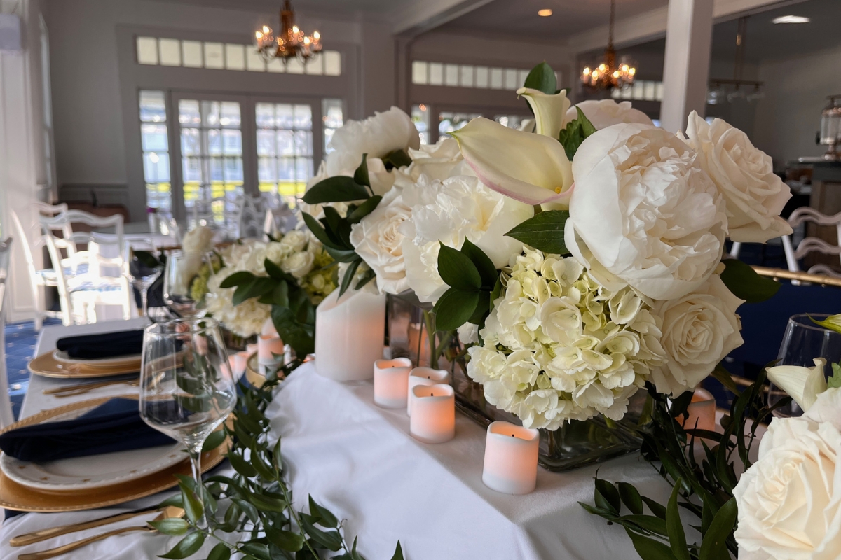 a table with white flowers and candles