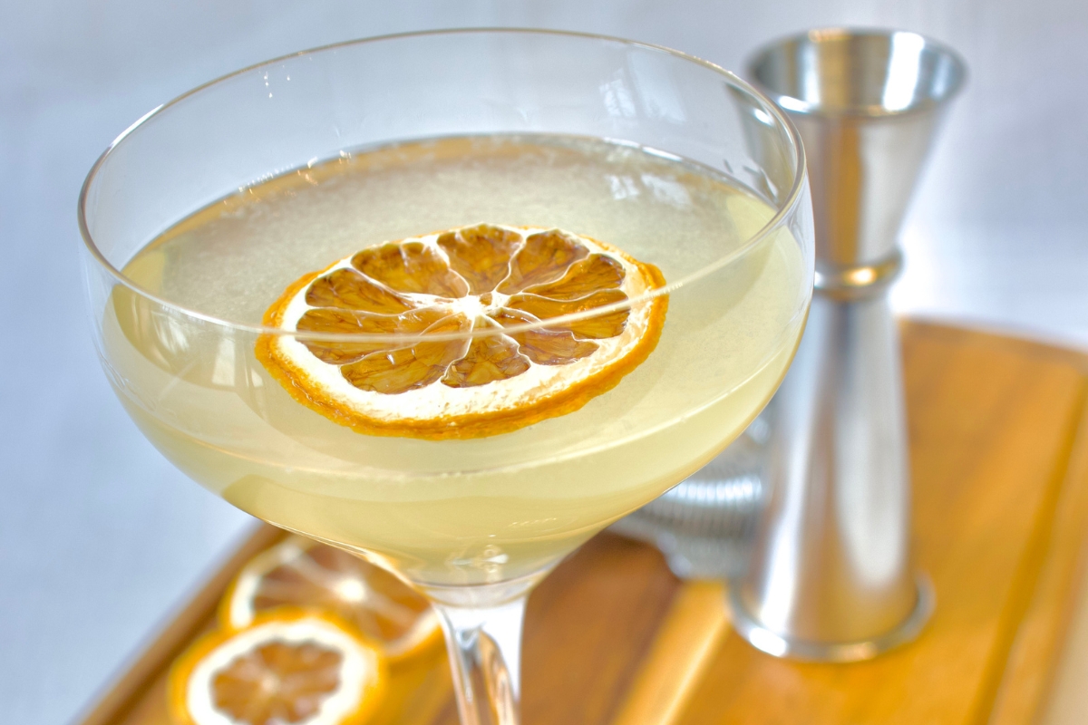 a glass of liquid with a slice of orange on it