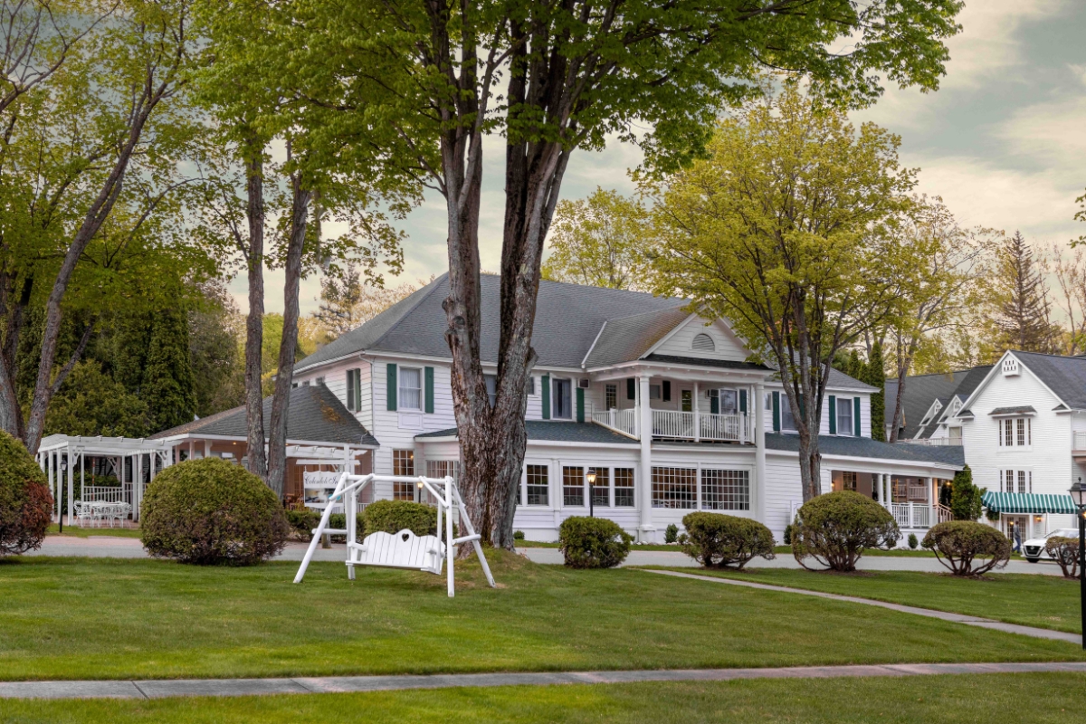 a large white house with trees and grass