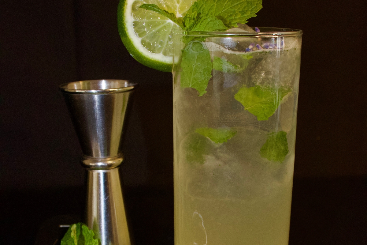 a glass with a drink and a slice of lime on top