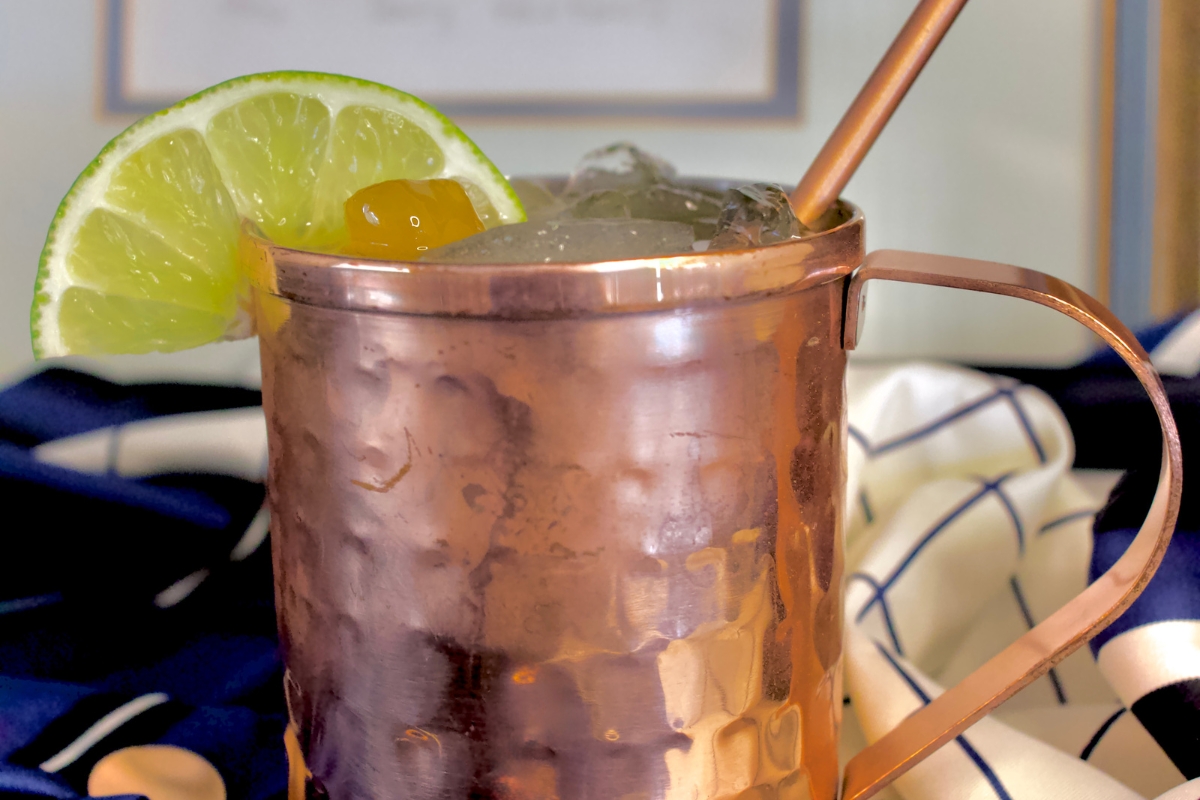 a copper mug with ice and lime wedges