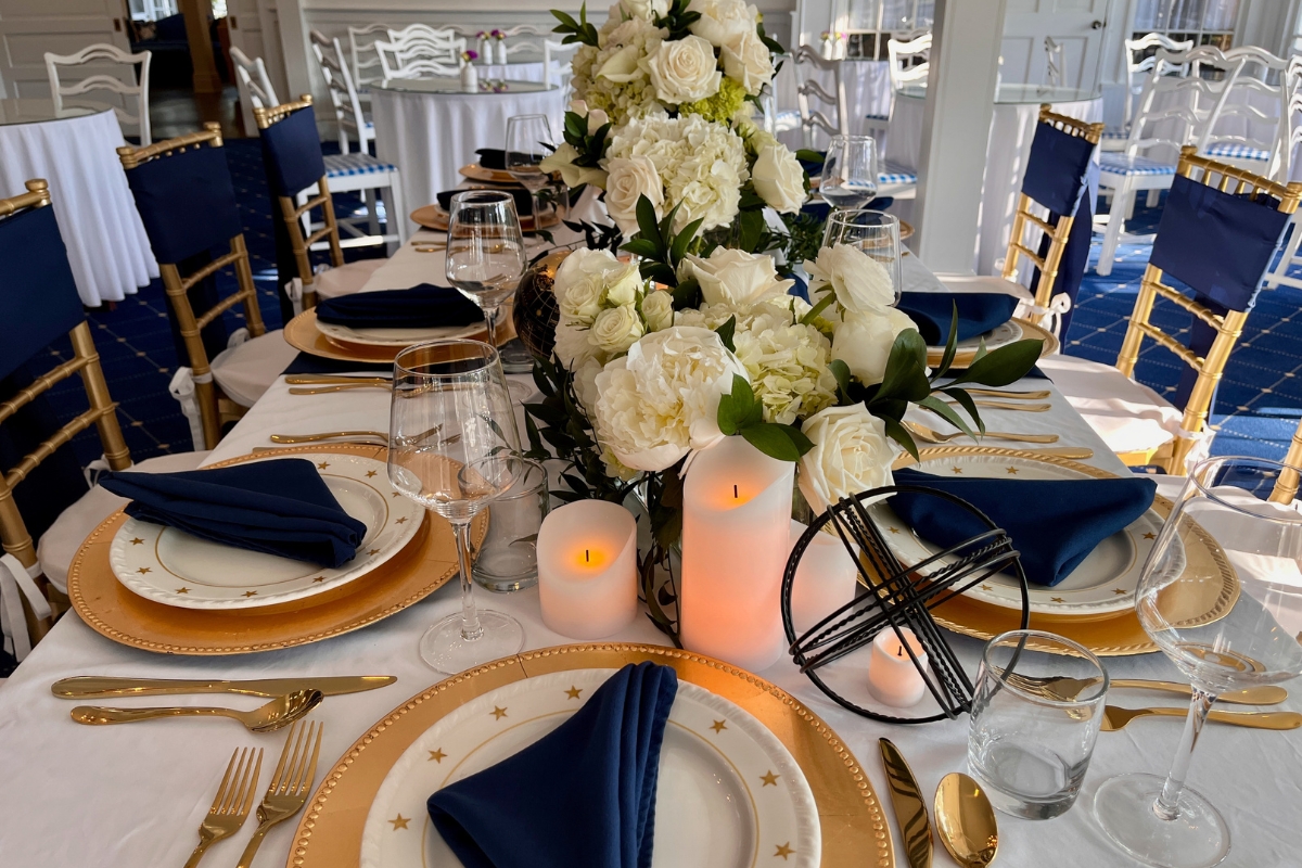 a table set with white flowers and candles
