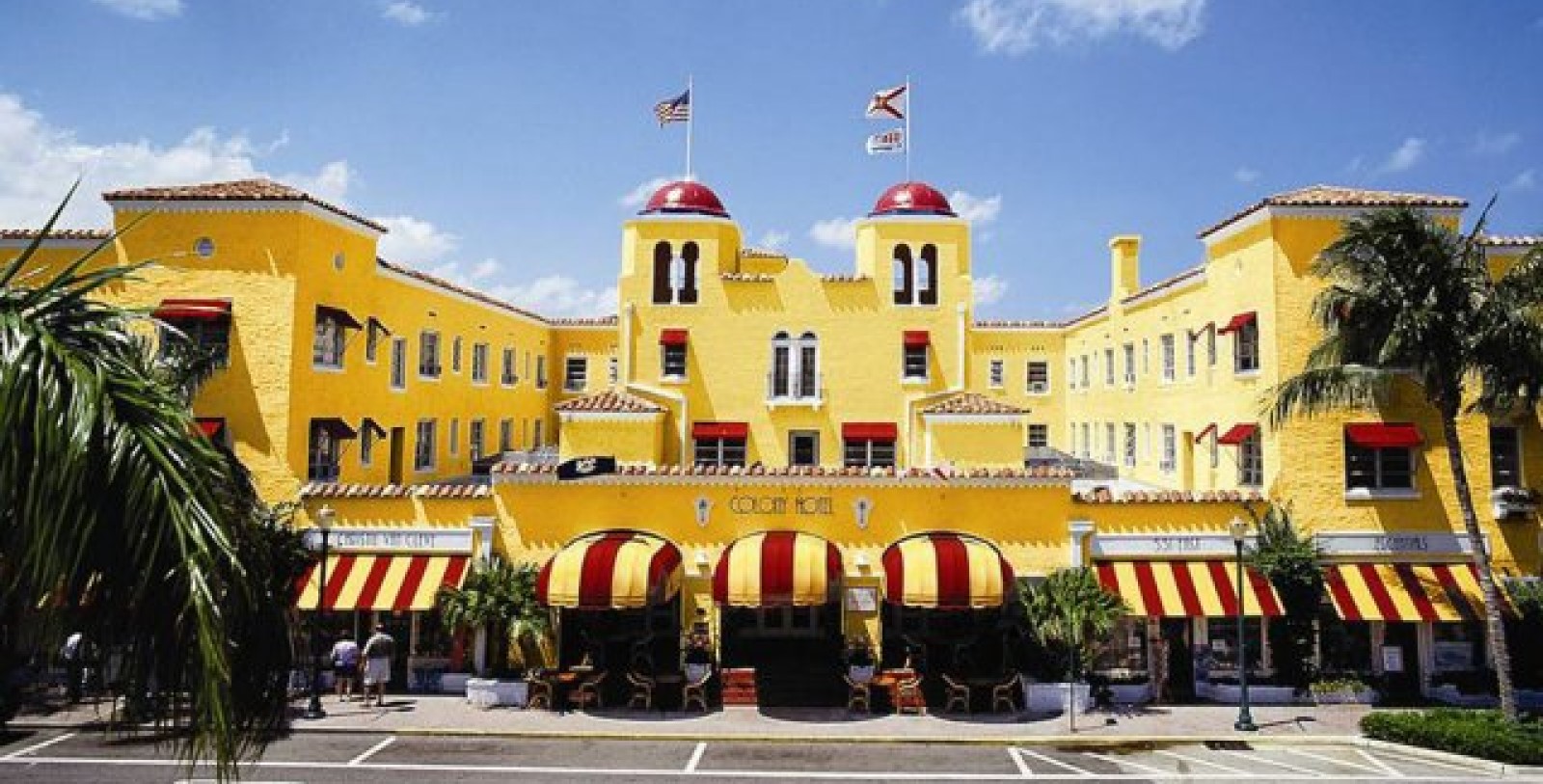 a yellow building with red and white awnings