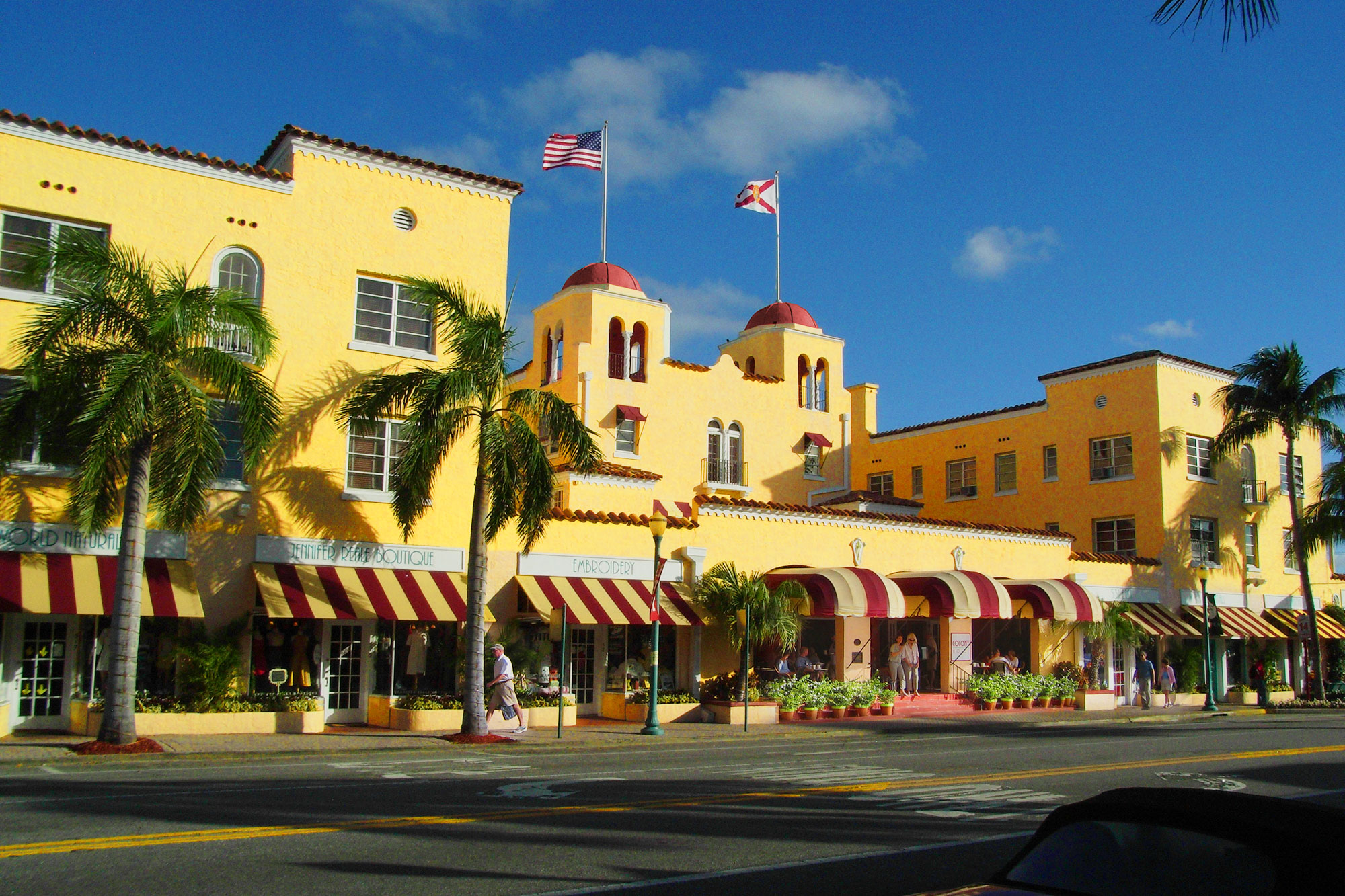 a yellow building with flags on top