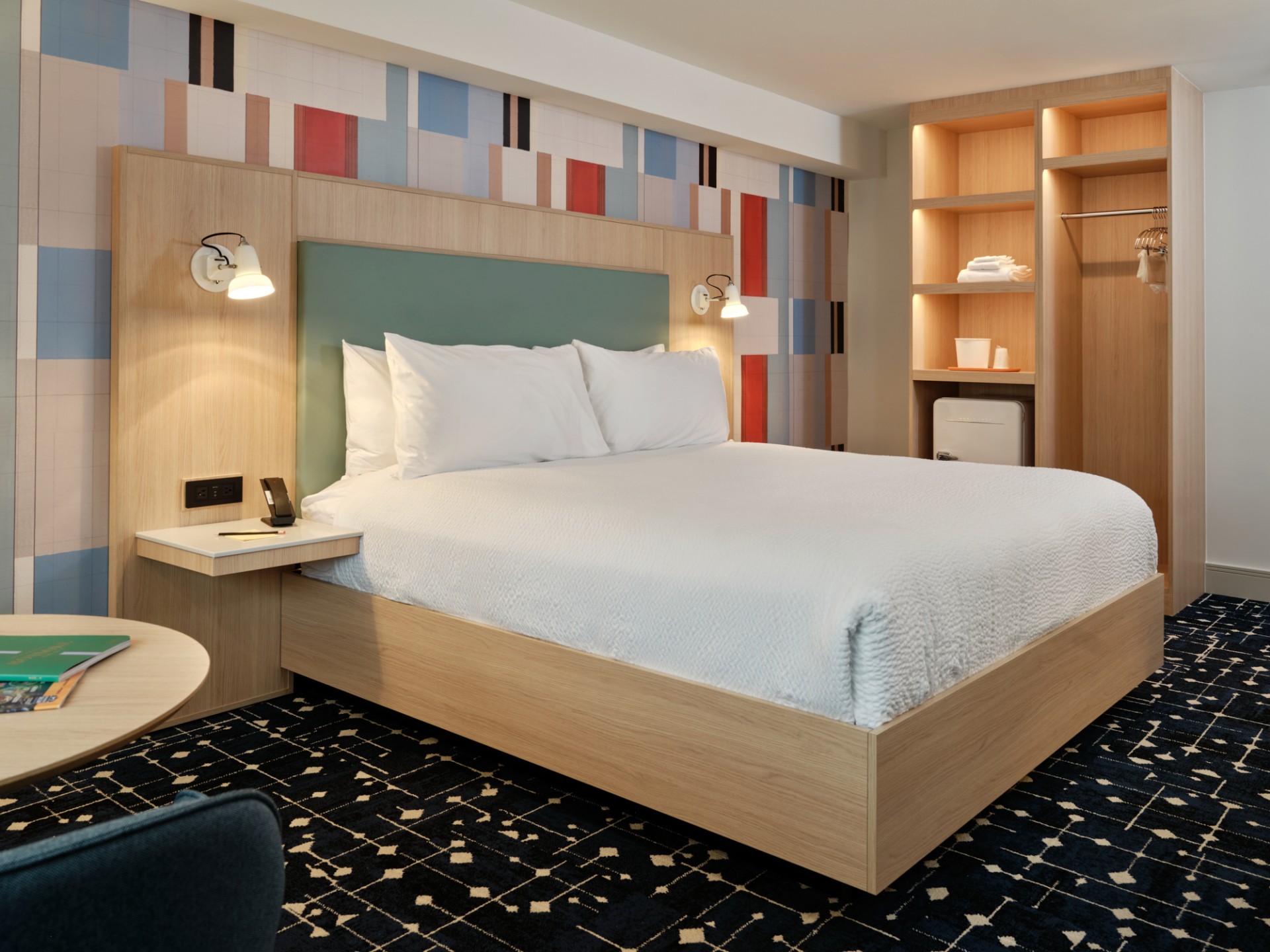 a bed with white sheets and a blue carpet