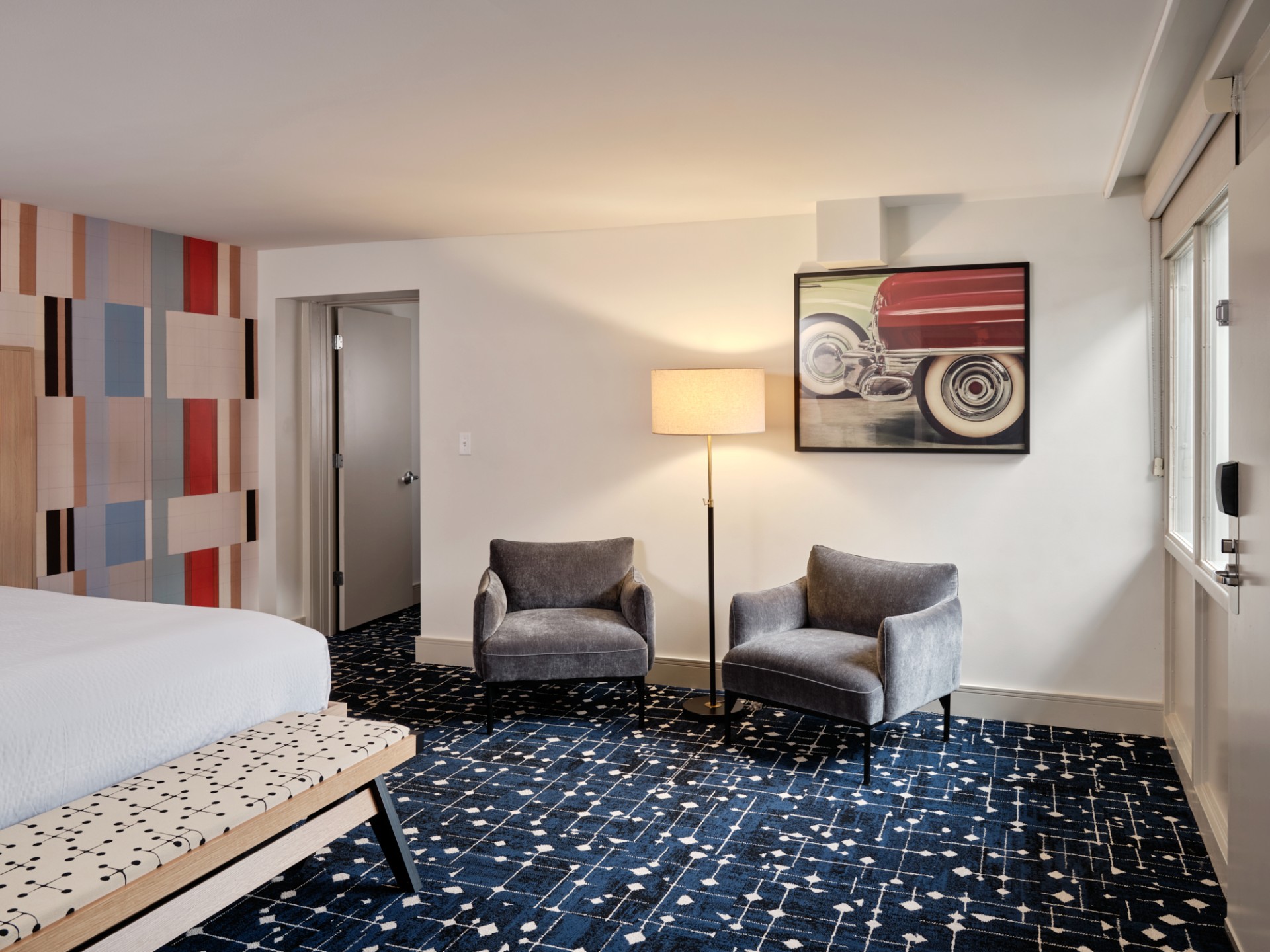 a room with a bed and chairs