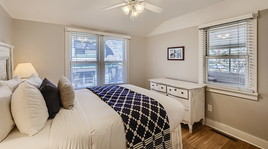 a bedroom with a bed and a ceiling fan