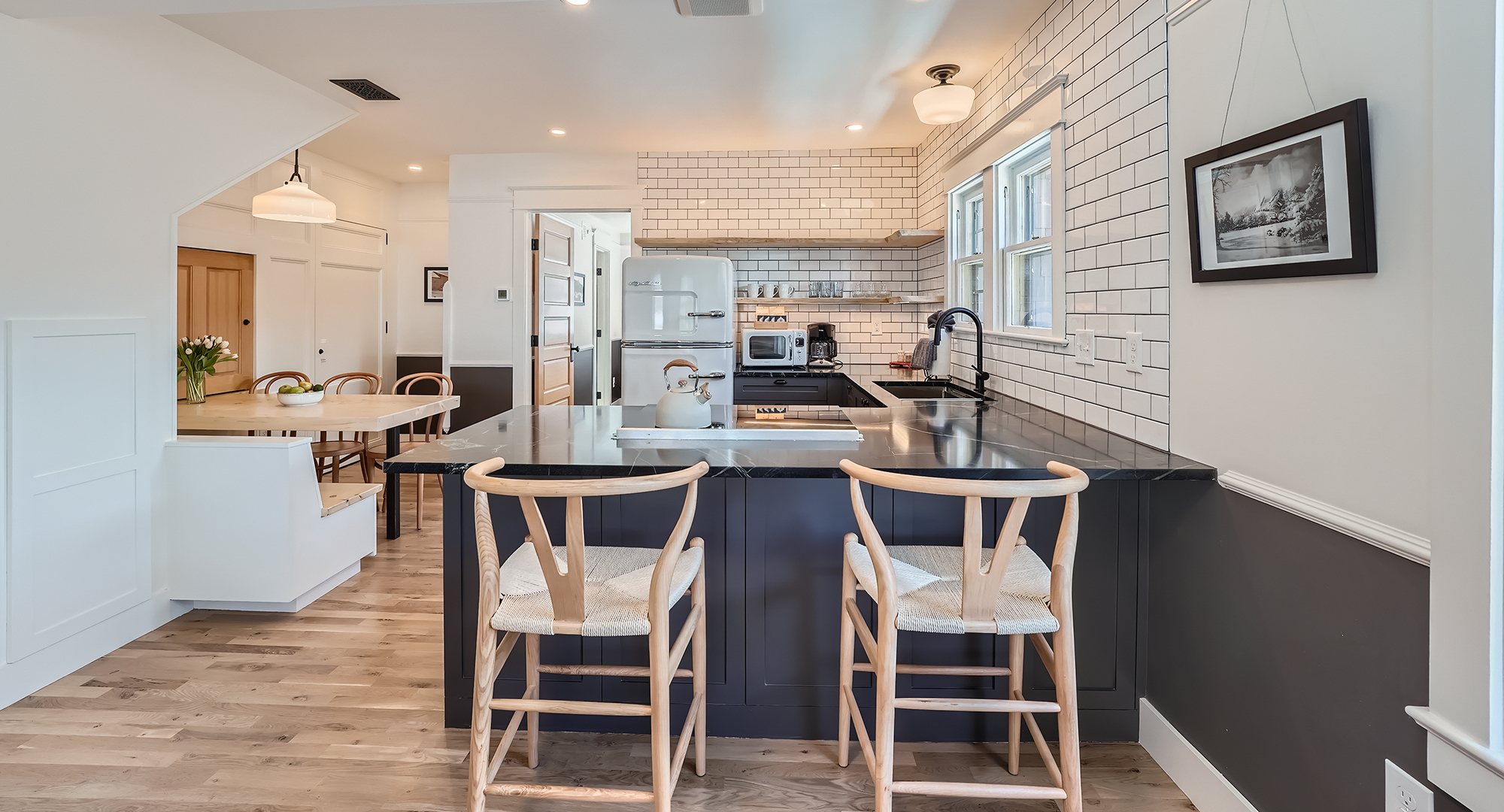 a kitchen with a black countertop and chairs