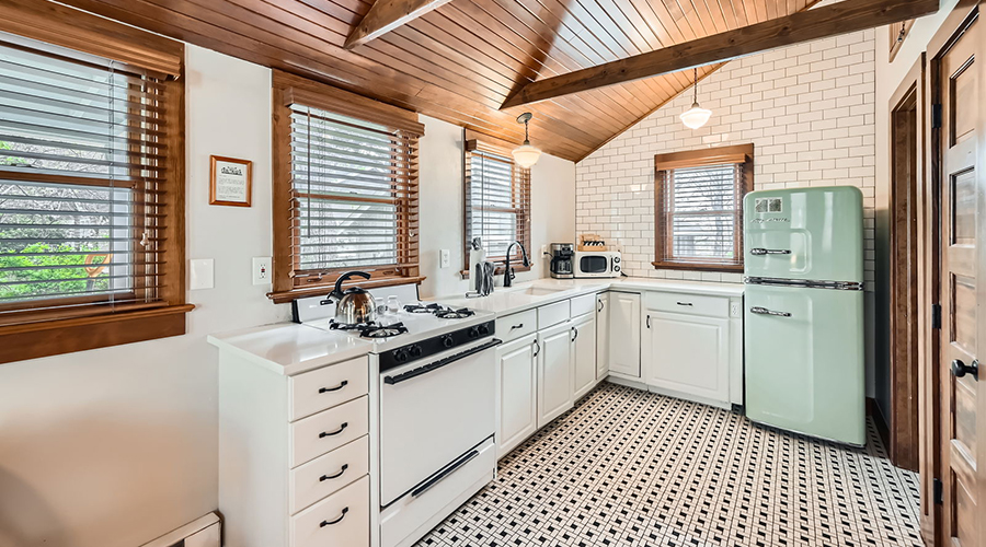 a kitchen with white cabinets and black appliances