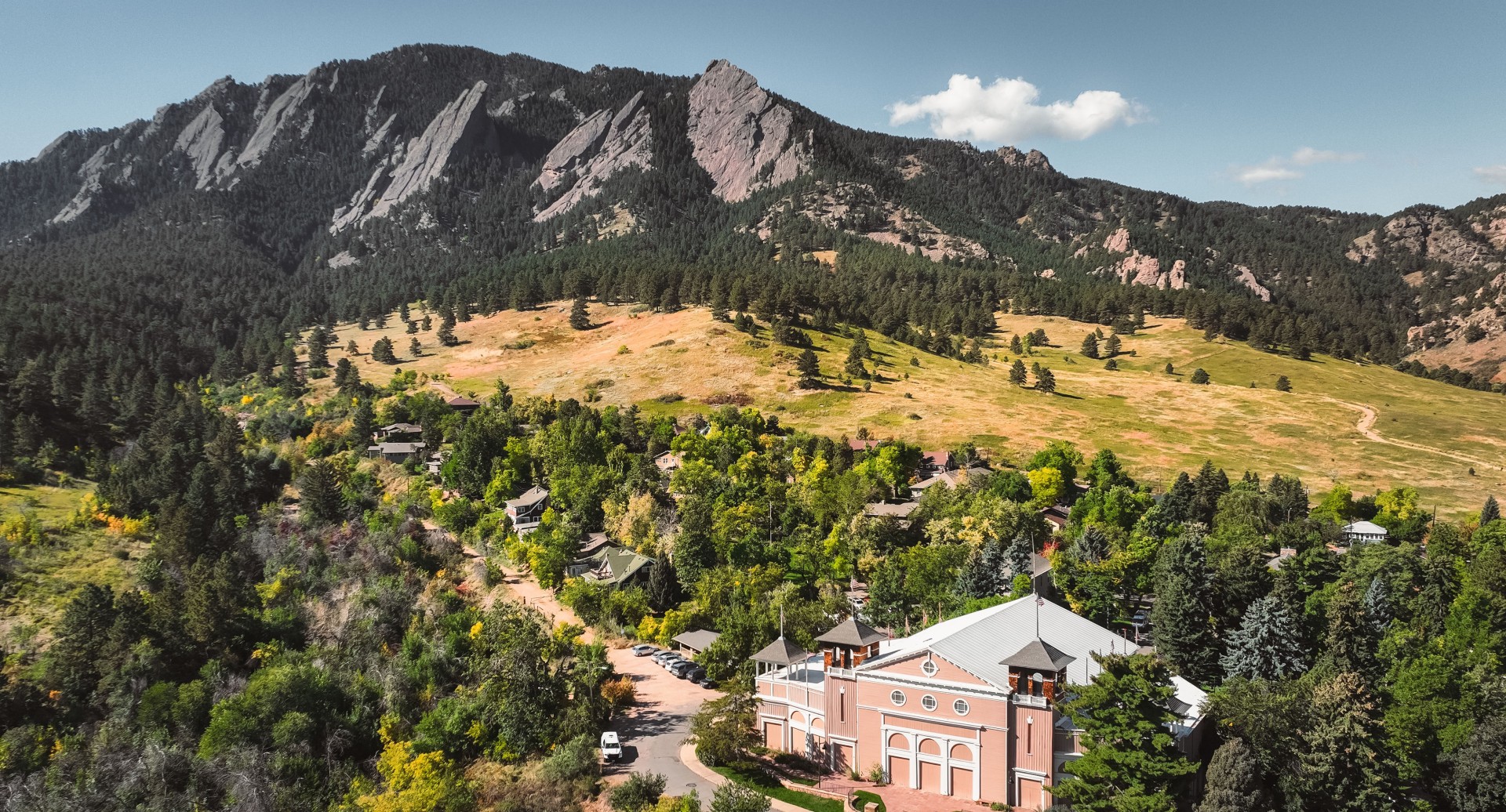 a building in a valley with trees and mountains