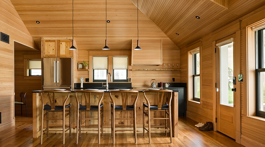 a kitchen with wood walls and a wooden ceiling