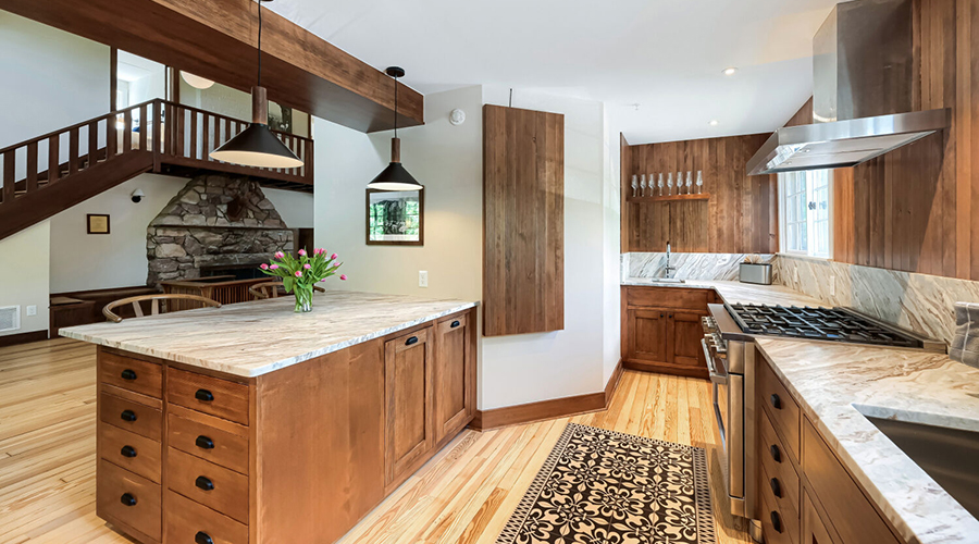 a kitchen with wood cabinets and a marble countertop