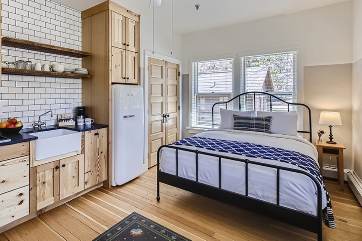 a bedroom with a bed and a refrigerator