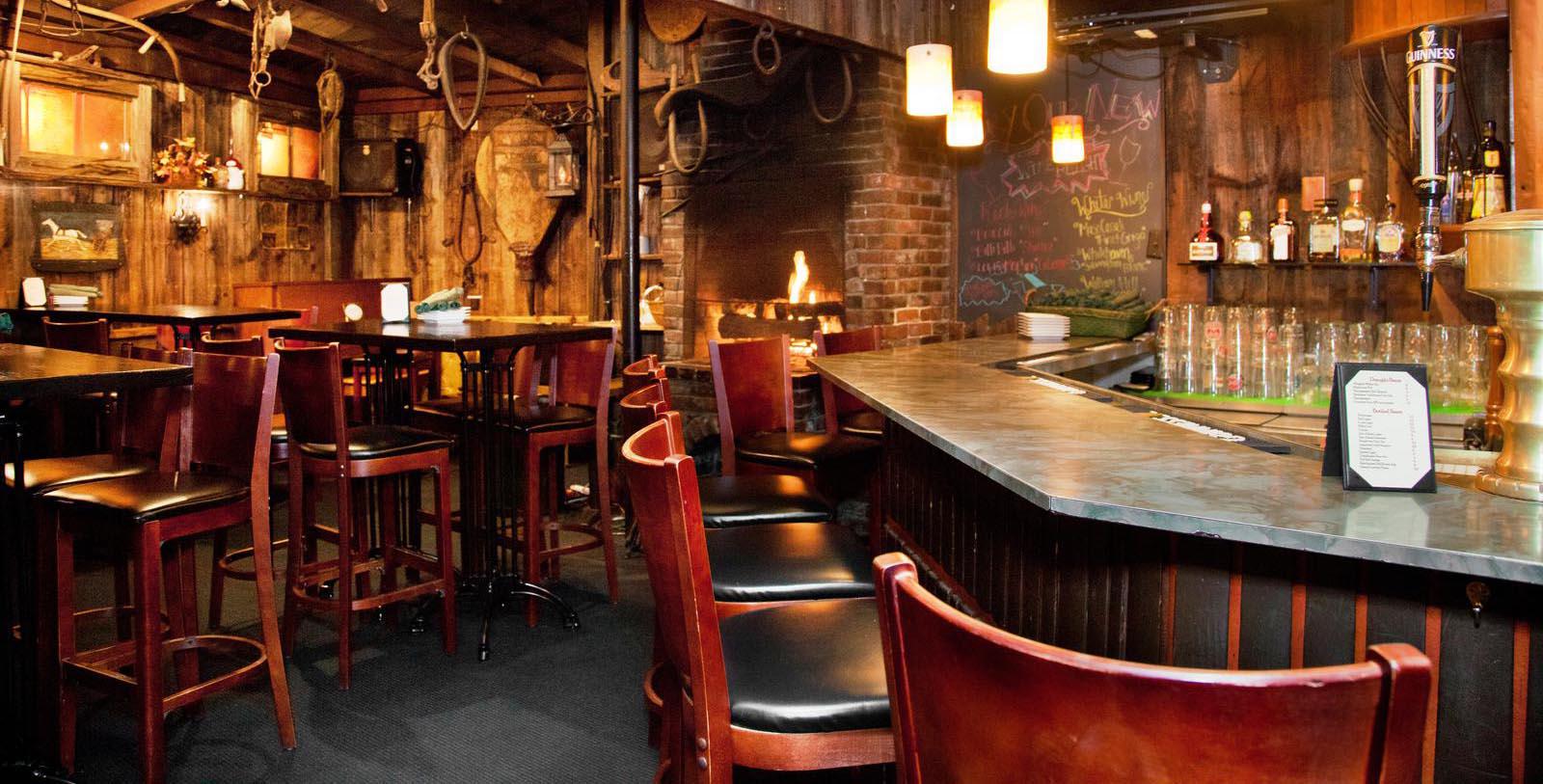 a bar with chairs and a fireplace