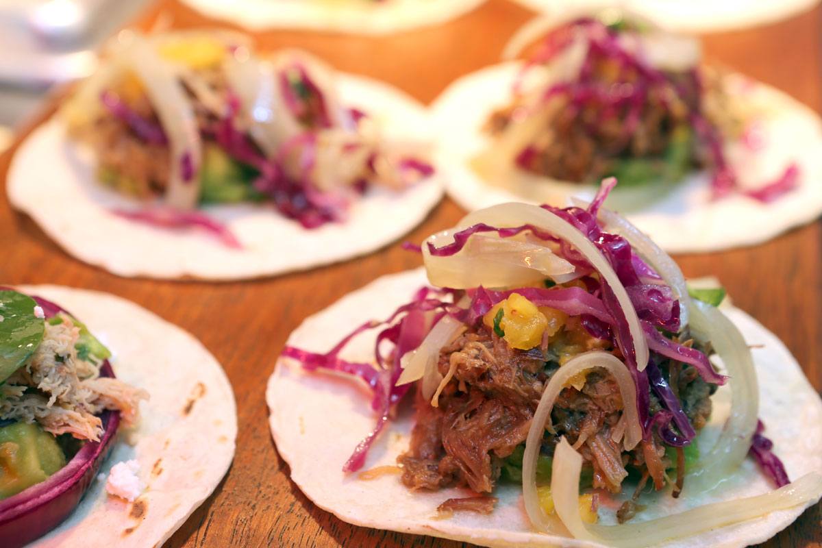 a group of tacos with meat and vegetables on them