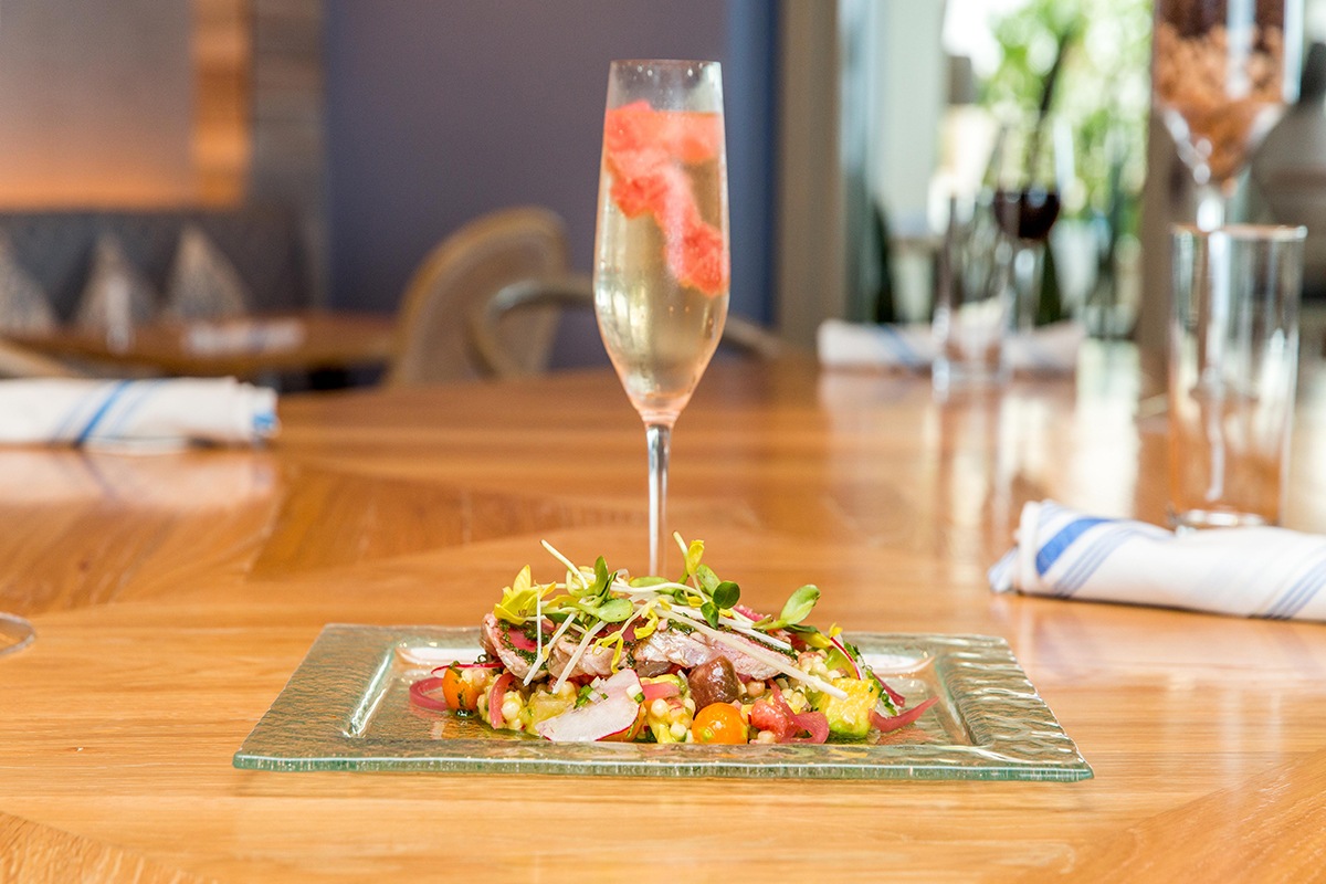 a glass of champagne next to a plate of food