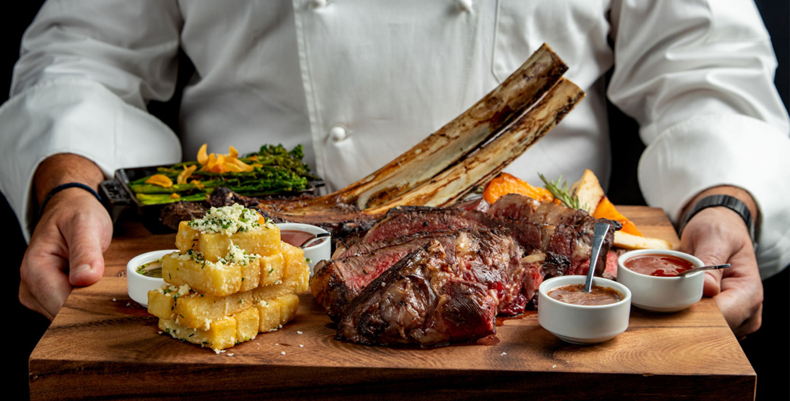 a chef in a white coat with a plate of meat