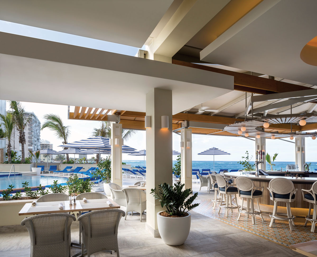 a restaurant with tables and chairs by a pool
