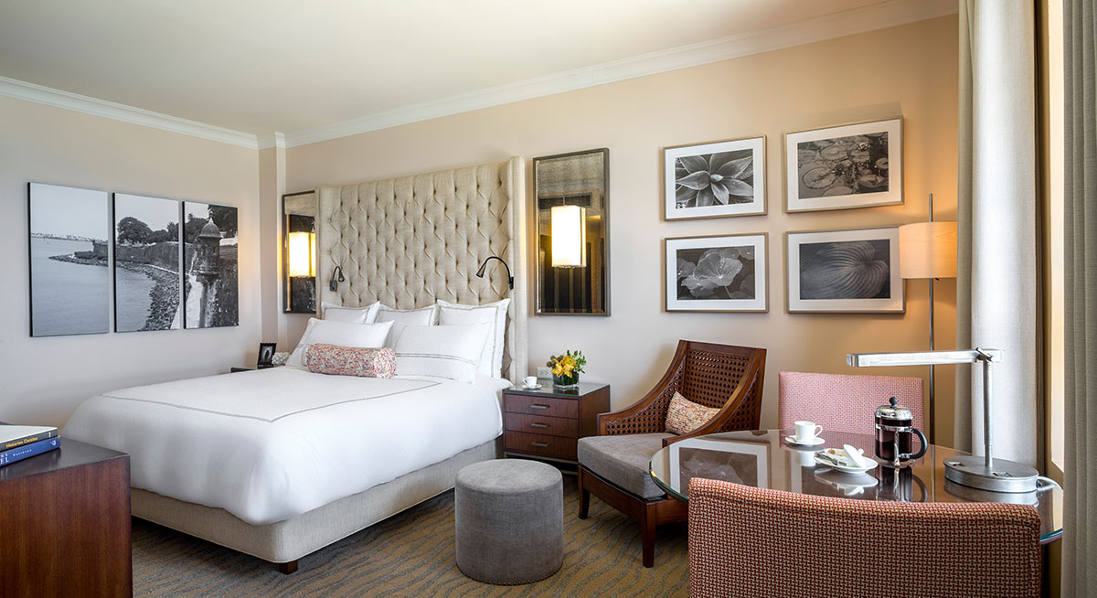 a room with a bed and chairs