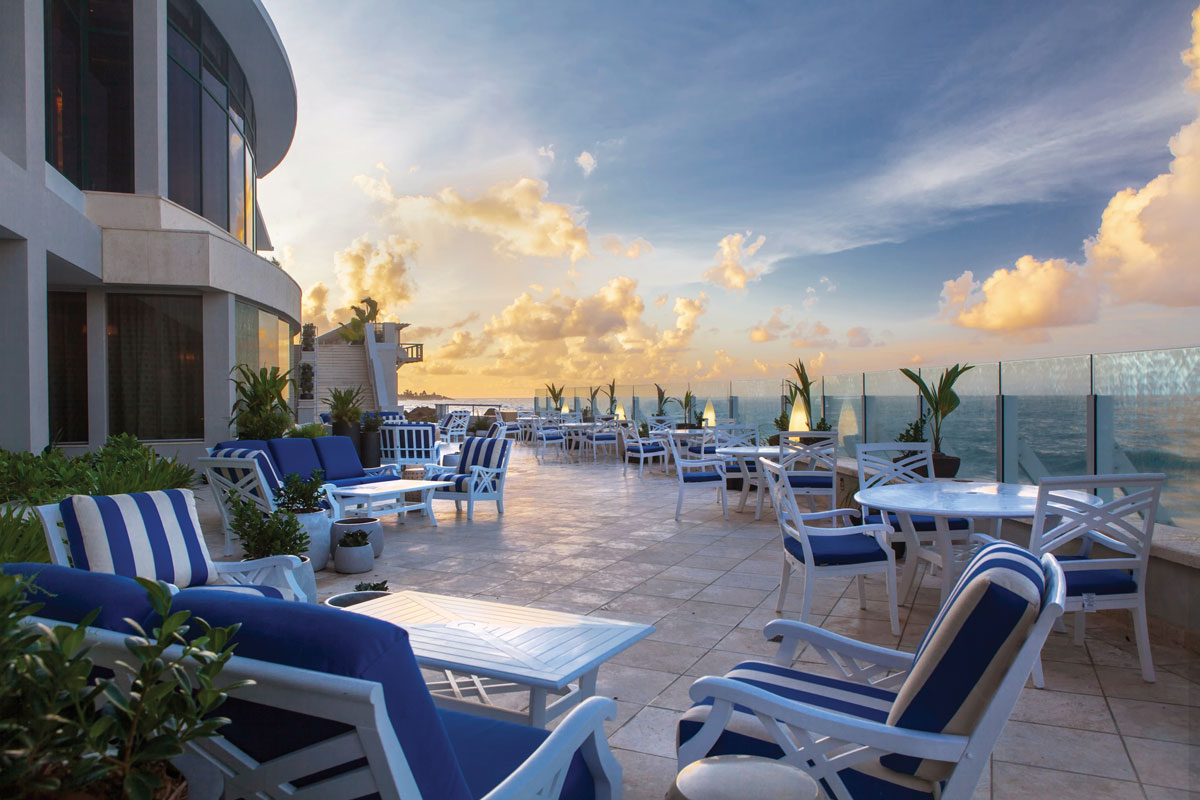 a patio with chairs and tables on a sunny day