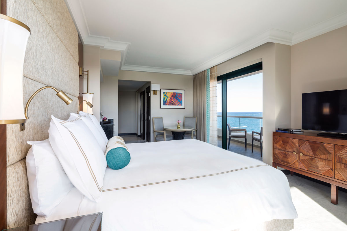 a bedroom with a large bed and a table and chairs