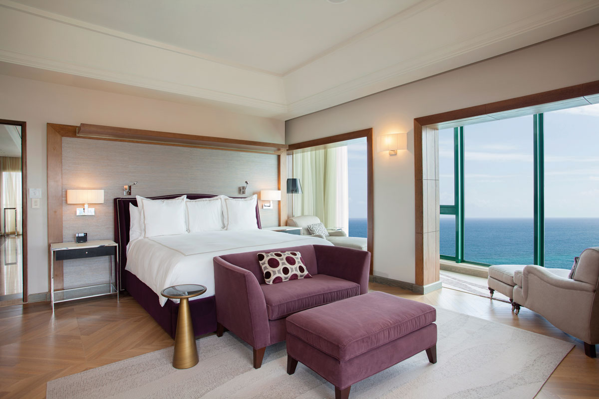 a bedroom with a bed and purple chairs