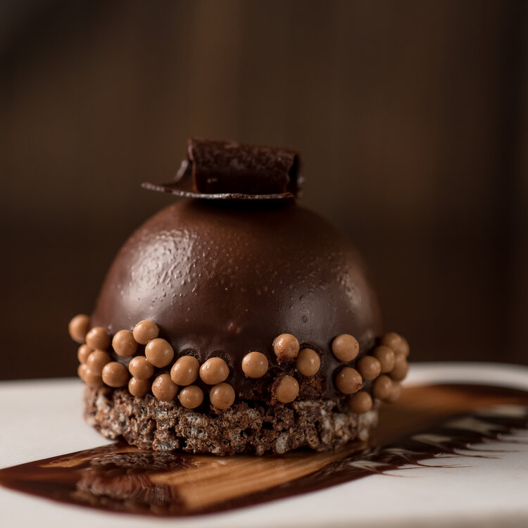 a chocolate dessert with a chocolate ball on top