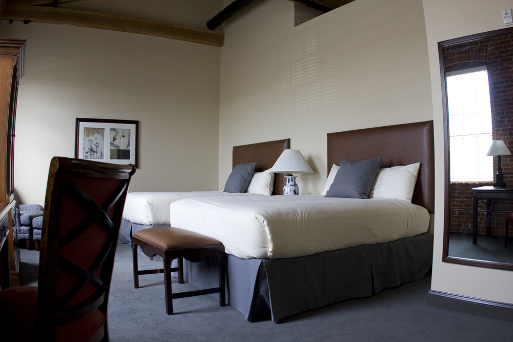 a room with two beds and a lamp