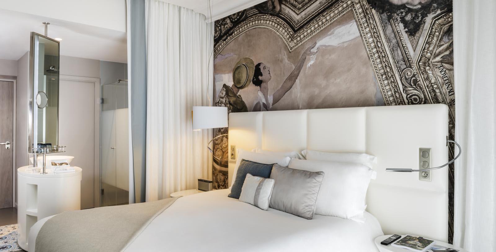 a bed with a painting on the wall