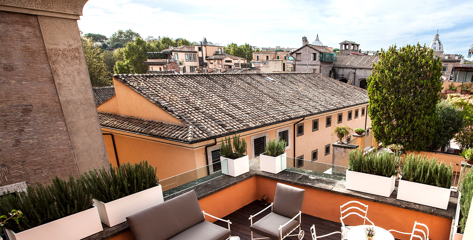 a rooftop patio with chairs and plants