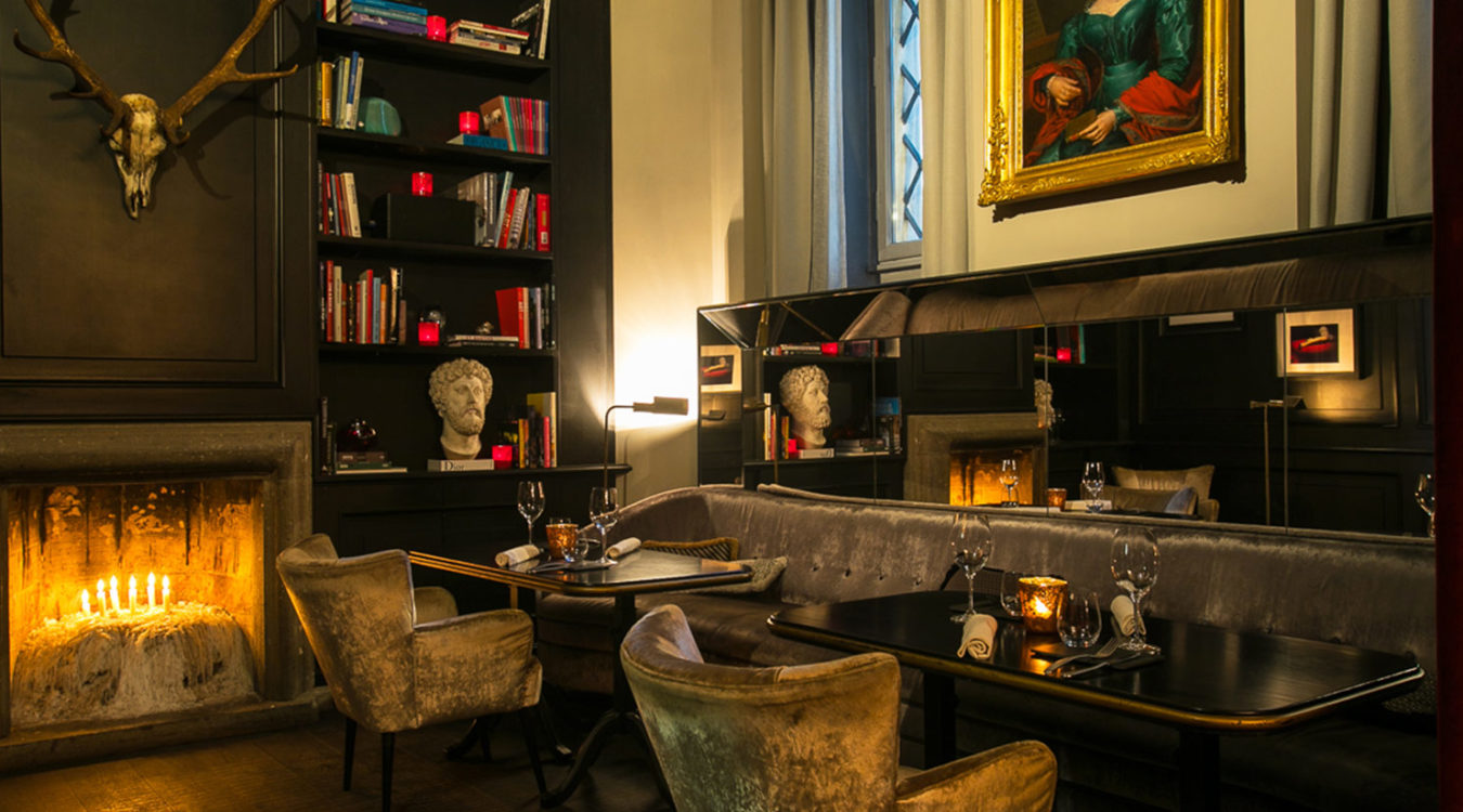 a room with a table and chairs and a fireplace