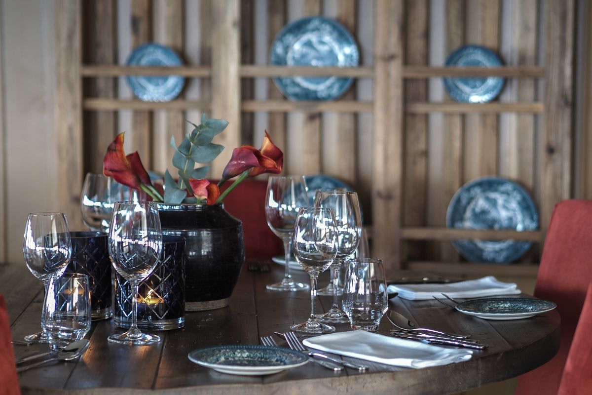 a table with wine glasses and a vase of flowers
