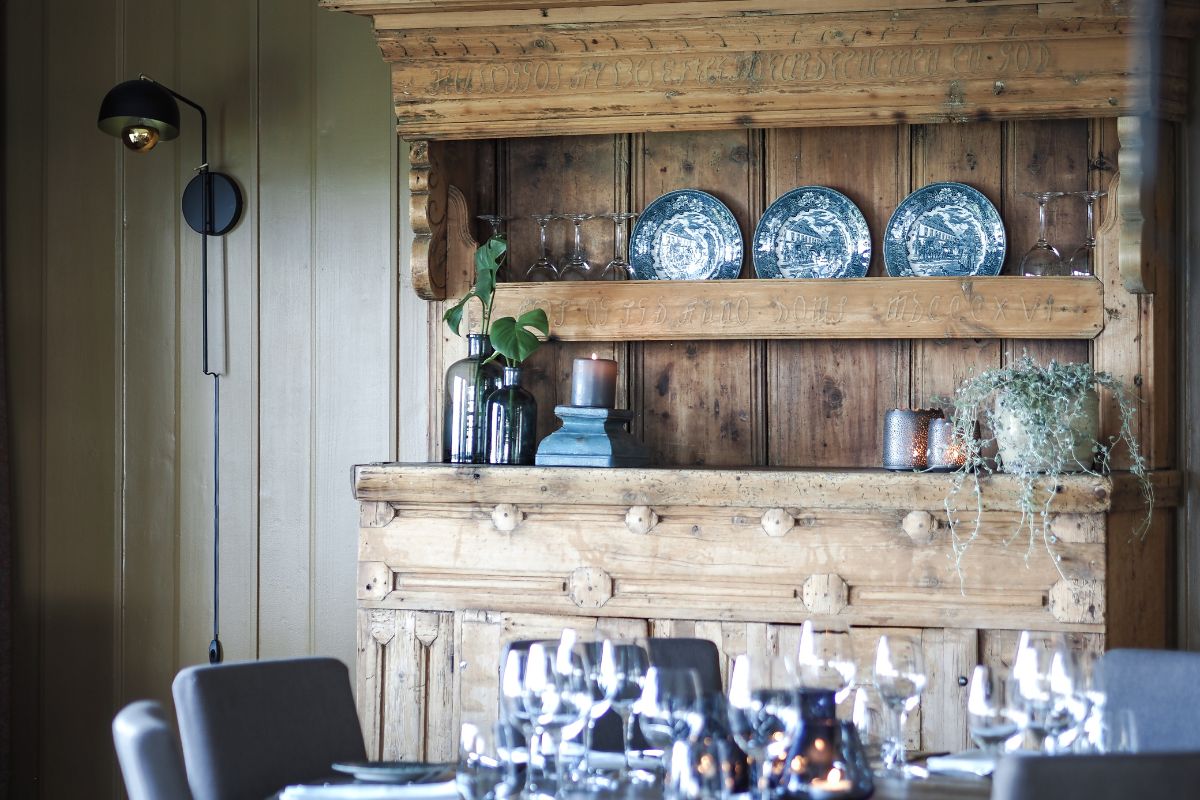 a table with plates on top and a shelf with candles