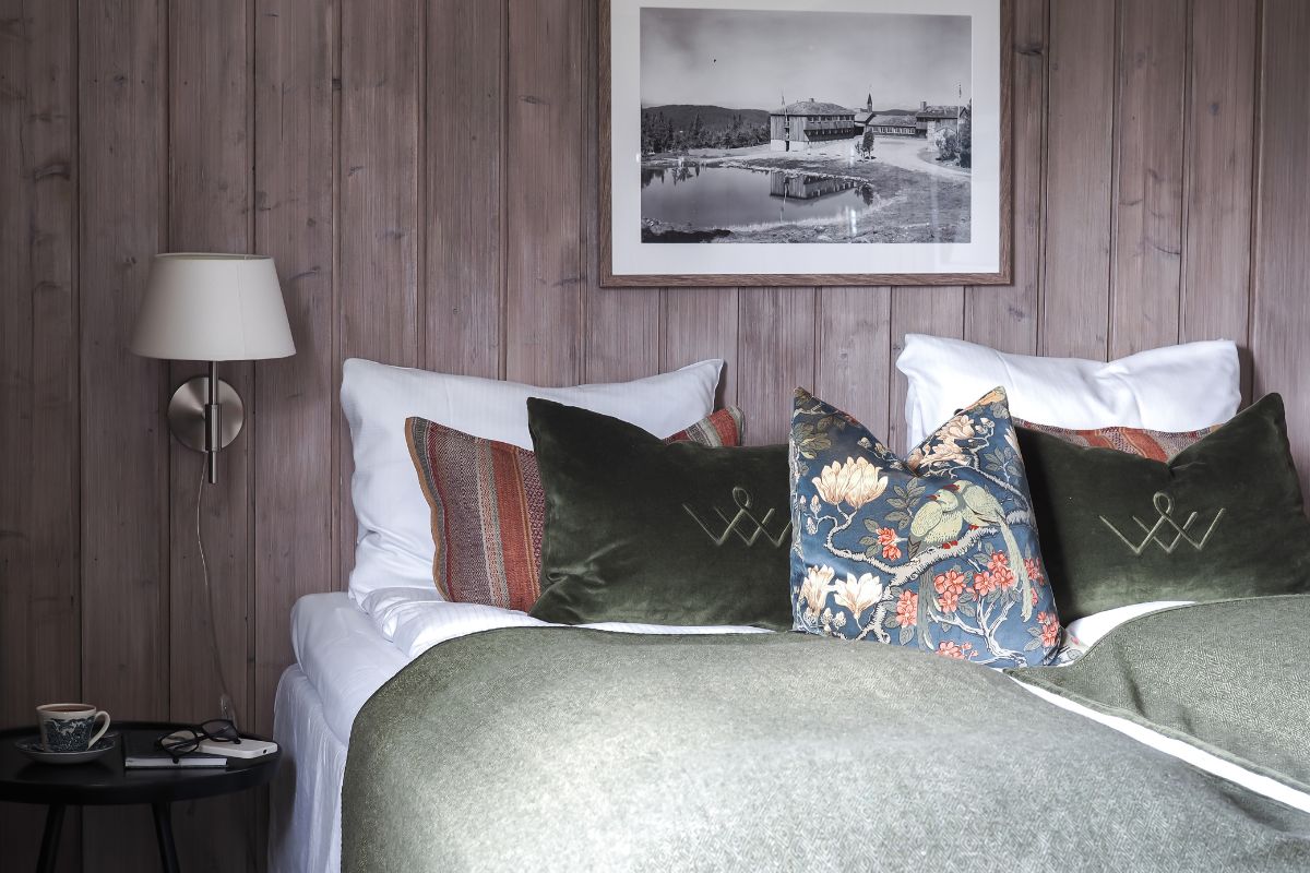 a bed with pillows and a picture on the wall