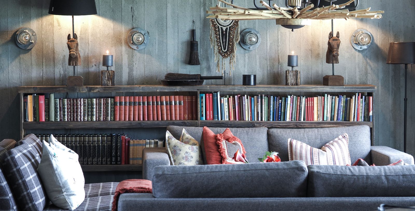 a couch with pillows in front of a bookshelf
