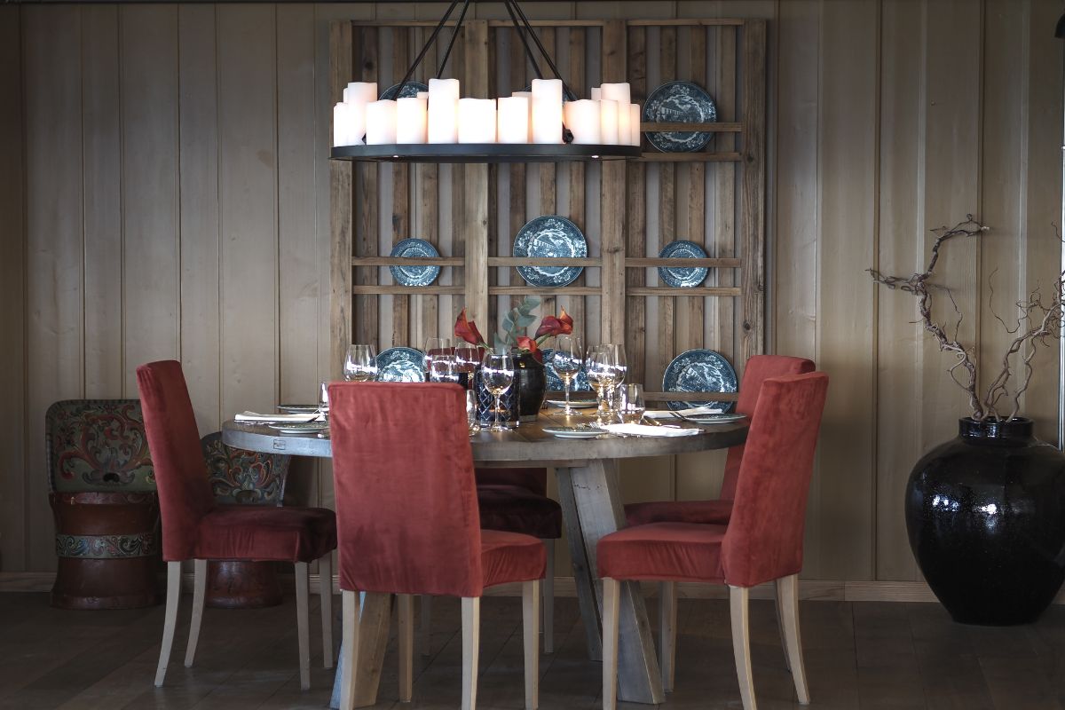 a table with red chairs and candles on it