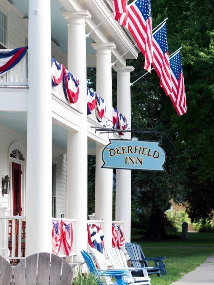 a white building with a blue sign and flags